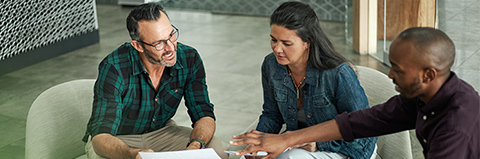 Agent sits with couple to discuss insurance coverage options.